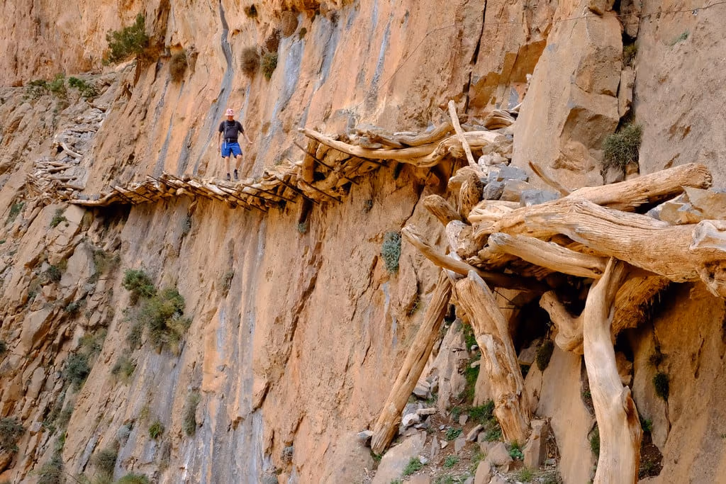 Log walkway pinned to cliff