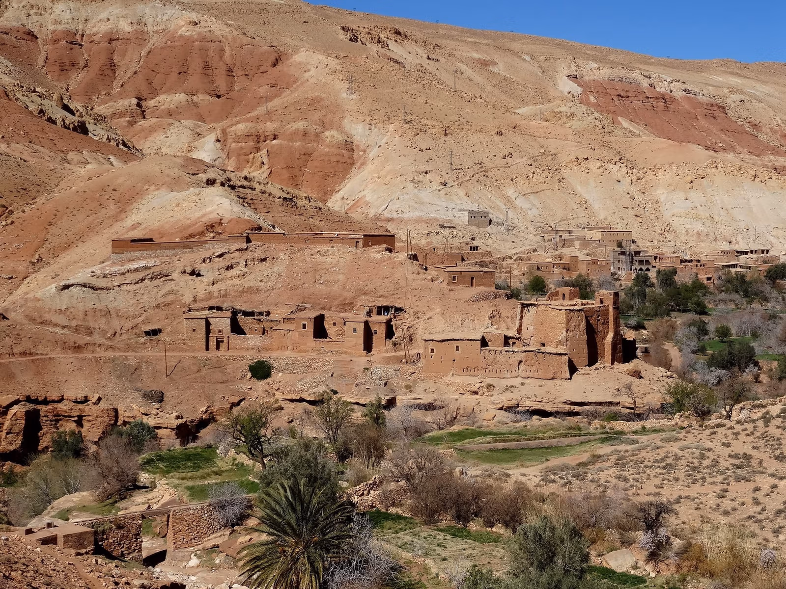 Ruined village red hill green fields