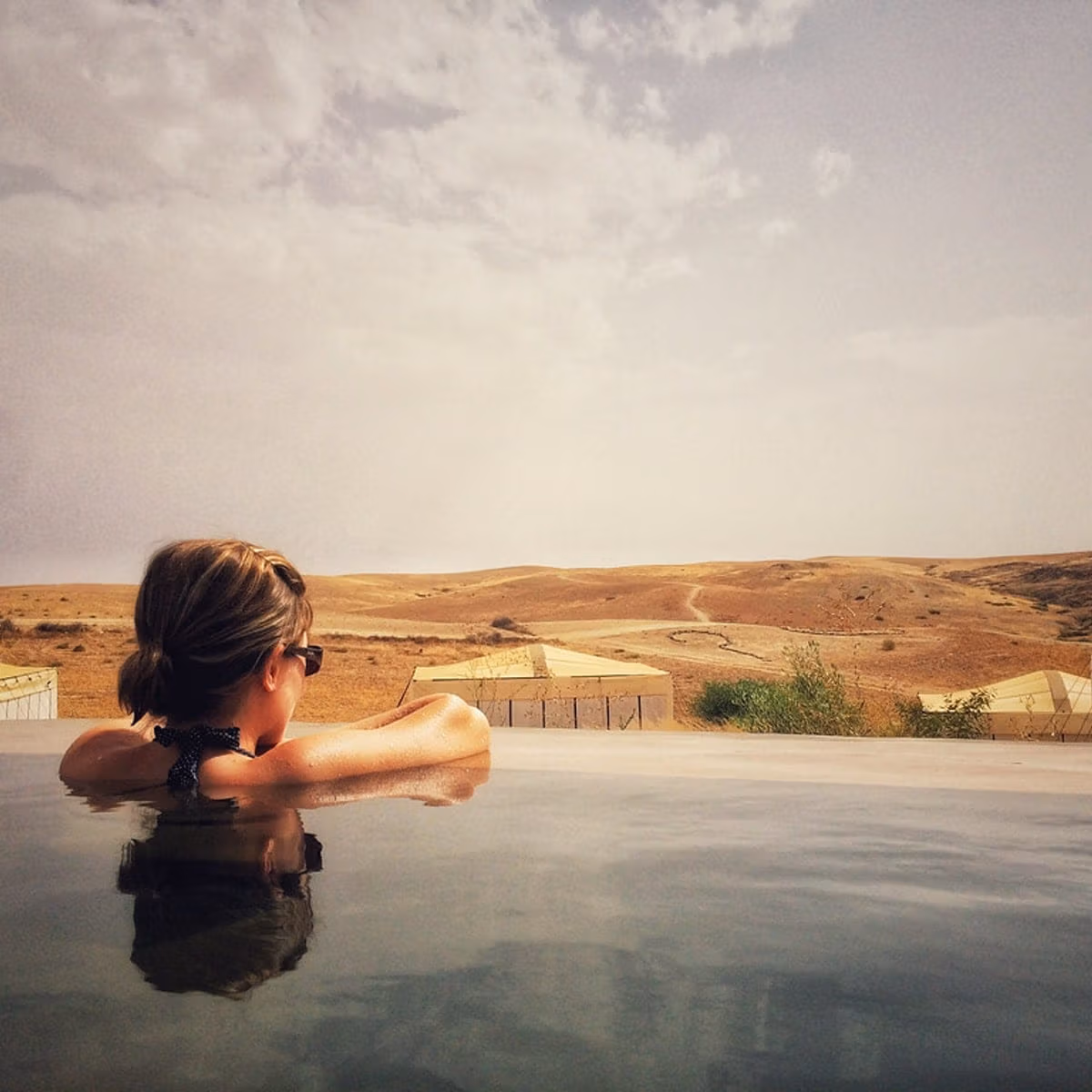 A camp pool looking out over the bare hills of the Agafay desert