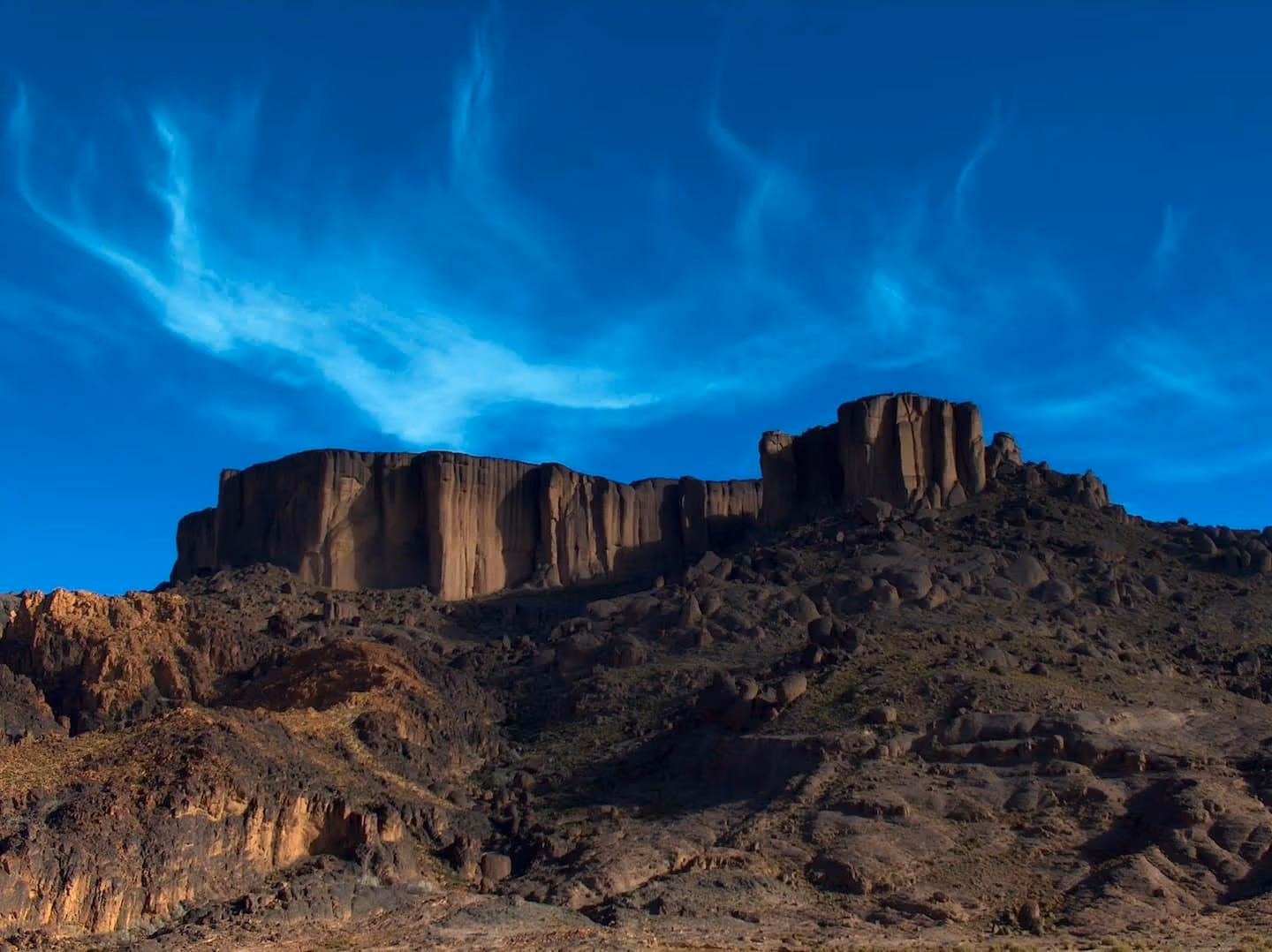 A dark volcanic mesa in the Jebel Saghro under a cirrus sky